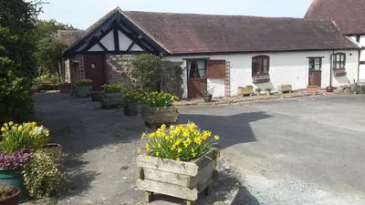 a house with a bunch of flowers in front of it at The Long Barn in Church Stretton