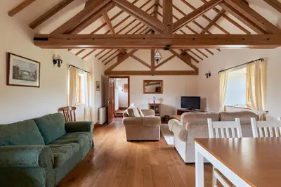 a living room with a couch and a table at The Long Barn in Church Stretton
