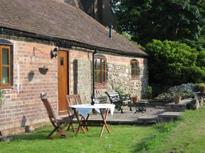 a table and chairs in front of a brick house at The Long Barn in Church Stretton