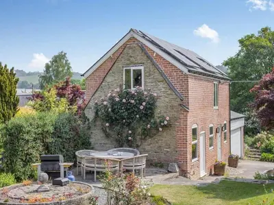 a brick house with a table in a yard at The Barrels at Leintwardine in Leintwardine