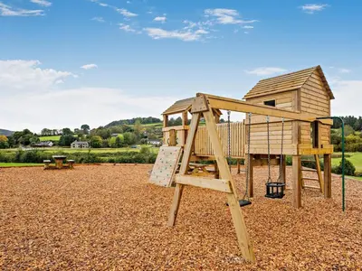 a wooden playground with a ladder and a house at 2 Bed in Rhayader oc-90276 in Saint Harmon