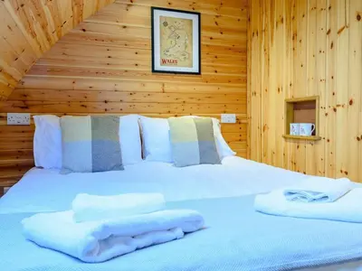 a bed in a wooden room with towels on it at 2 Bed in Rhayader oc-90274 in Saint Harmon