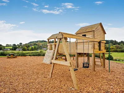 a wooden playground with a ladder and a house at 1 Bed in Rhayader oc-90285 in Saint Harmon
