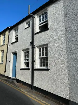 a white building with windows on a street at The Retreat - 2 bed cottage in Aberdovey in Aberdyfi
