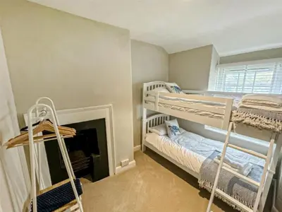 a bedroom with two bunk beds and a fireplace at The Retreat - 2 bed cottage in Aberdovey in Aberdyfi