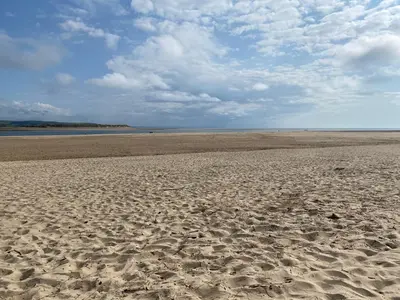 an empty beach with footprints in the sand at The Retreat - 2 bed cottage in Aberdovey in Aberdyfi