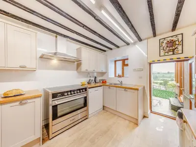 a kitchen with white cabinets and a large window at 3 Bed in Corwen oc-90459 in Corwen
