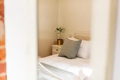 a small bedroom with a bed with a plant on it at Pigeon House - Unique Barn with private garden, hot tub and wood burner in Shrewsbury