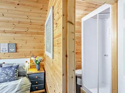 a room with wooden walls and a bed and a bathroom at 1 Bed in Church Stretton oc-90929 in All Stretton