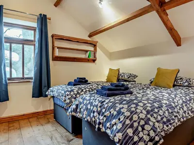 a bedroom with a bed with blue sheets and a window at 2 Bed in Brecon oc-91085 in Llangorse