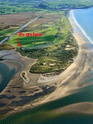 an aerial view of a beach with the words we are here at Little Curlew, Ynyslas, Borth in Borth