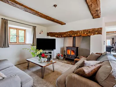 a living room with a couch and a fireplace at 4 Bed in Hereford oc-92039 in Clyro