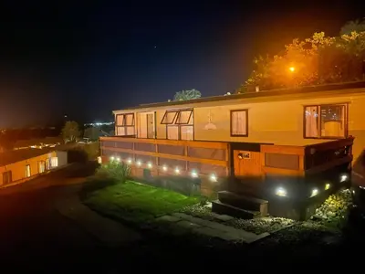 a house with lights in front of it at night at Haven on the Hill 2 Bed Caravan with Town Views of Aberystwyth F7 in Aberystwyth