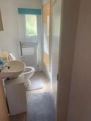 a white bathroom with a toilet and a sink at Hilltop Hideaway 2 Bed Caravan with Panoramic Town Scenery in Aberystwyth Holiday Village F8 in Aberystwyth