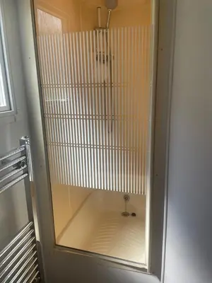 a shower with a glass door in a bathroom at Hilltop Hideaway 2 Bed Caravan with Panoramic Town Scenery in Aberystwyth Holiday Village F8 in Aberystwyth