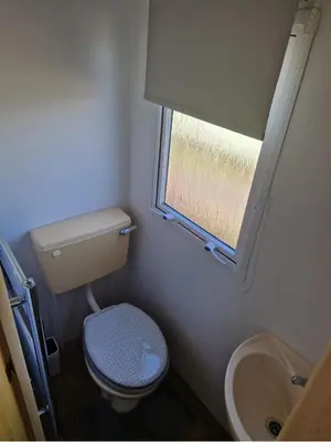 a small bathroom with a toilet and a sink at Hilltop Hideaway 2 Bed Caravan with Panoramic Town Scenery in Aberystwyth Holiday Village F8 in Aberystwyth