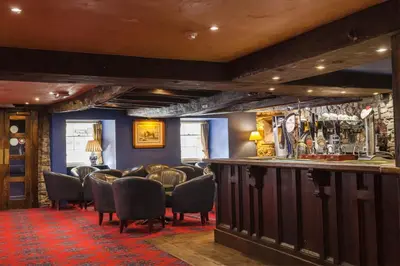 a bar in a pub with chairs and a bar counter at The Kings Head Inn in Llandovery