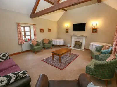 a living room with a fireplace and a tv at Finest Retreats - The Walton in Onibury
