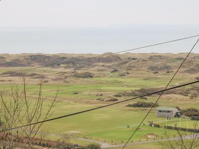 a view of a green field with mountains in the background at Hafod Y Bryn in Harlech