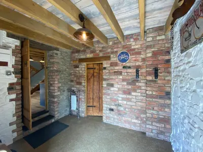 a room with a brick wall and a wooden door at No 2 Dolheulog Aberaeron in Aberaeron