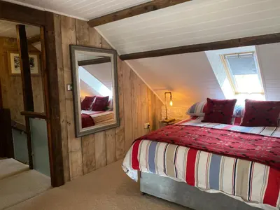 a bedroom with a bed and a large mirror at No 2 Dolheulog Aberaeron in Aberaeron