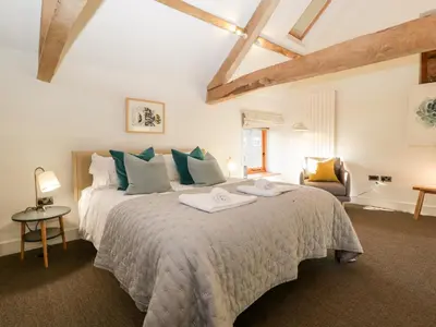 a bedroom with a large bed with blue pillows at Barn Cottage in Leominster