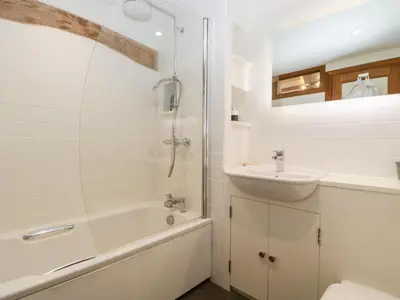 a white bathroom with a sink and a shower at Barn Cottage in Leominster