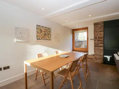 a dining room with a wooden table and chairs at Barn Cottage in Leominster