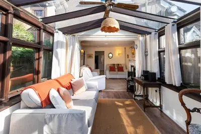 a living room with white furniture and windows at Toad Hall in Ludlow
