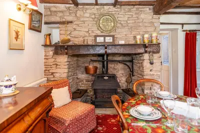 a living room with a table and a stone fireplace at Toad Hall in Ludlow