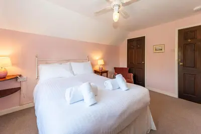 a bedroom with a large white bed with two pillows at Toad Hall in Ludlow