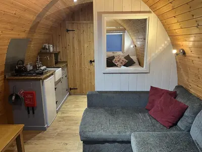 a living room with a couch in a tiny house at Mountain Edge Resort Mega pod 4 with Hot Tub in Church Stretton