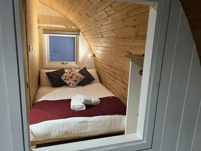 a small bed in a small room in a tiny house at Mountain Edge Resort Mega pod 6 with Hot Tub in Church Stretton