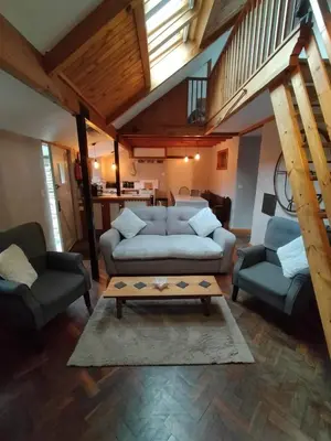 a living room with a couch and two chairs and a table at Glan Y Morfa Bach The Stone Cottage in Tywyn