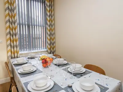 a table with plates and glasses and a bowl of fruit at Afonwy House in Rhayader