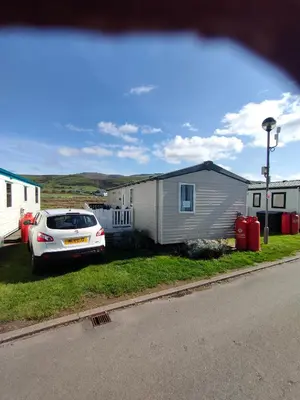 a car parked in front of a tiny house at M&C Caravan Hire Sunnysands in Barmouth