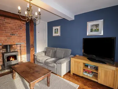 a living room with a couch and a tv and a fireplace at Wayside House in Craven Arms
