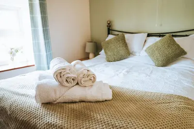a bedroom with a bed with towels on it at Luxury 5-Bed Farmhouse - Sleeps 8 & Hot Tub in Brecon