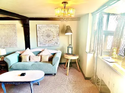 a living room with a blue couch and a table at Little Libertys in Shrewsbury