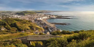 a town on a hill next to the ocean at Spacious Luxury Escape with Sea Views and Pet Friendly at Clarach Bay in Aberystwyth
