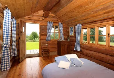 a bedroom with a bed in a wooden cabin at Spacious Holiday Cottage with Scenic Views in Church Stretton