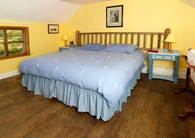 a bedroom with a large bed with blue pillows at Spacious Holiday Cottage with Scenic Views in Church Stretton