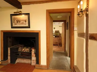 a living room with a fireplace with a picture on the wall at Spacious Holiday Cottage with Scenic Views in Church Stretton