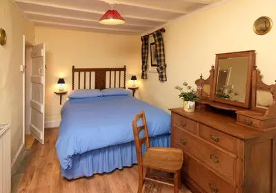 a bedroom with a bed and a dresser and a mirror at Spacious Holiday Cottage with Scenic Views in Church Stretton