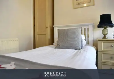 a bedroom with a bed with a pillow and a lamp at Town Centre Period Property by Shrewsbury Abbey in Shrewsbury