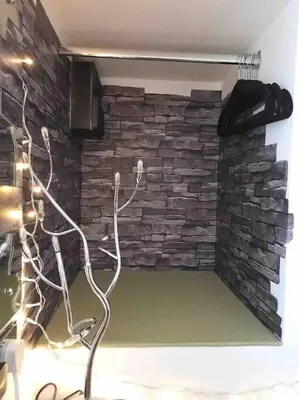 a bathroom with a stone wall with a shower at The Walkers' Cwtch in Ffestiniog