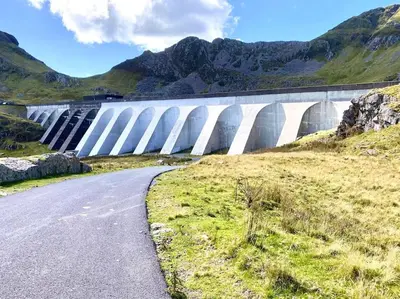 a large dam with a road in front of it at The Walkers' Cwtch in Ffestiniog