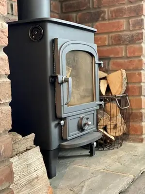 a gray stove sitting next to a brick wall at Aragon Cottage in Ludlow