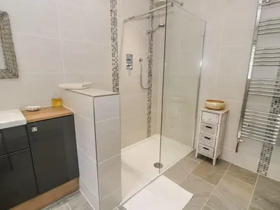 a bathroom with a shower with a glass door at Ty Ni in Dyffryn