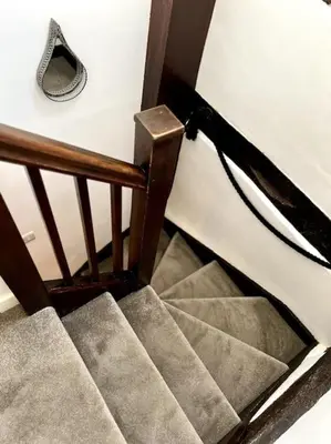 a set of stairs in a stair case with a hand rail at Hideaway Cottage in Ludlow